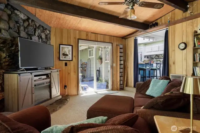 Rock fireplace at left fronted by a combination electric FP/TV stand combo. Sliders to very private patio, kitchen thru doorway at right.