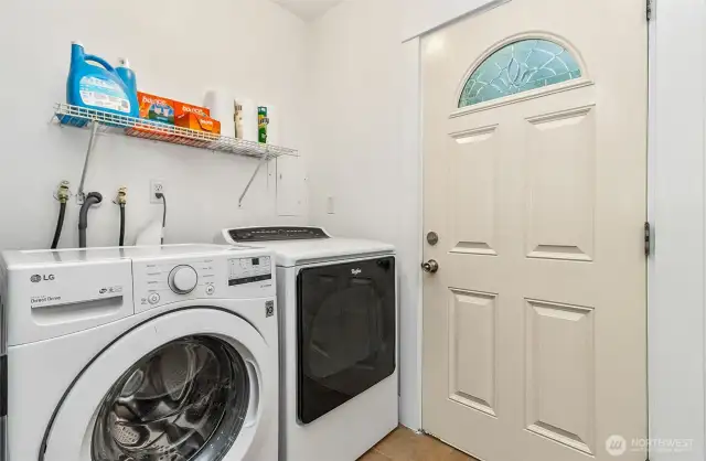 Utililty area with washer, dryer, and door leading out to covered deck