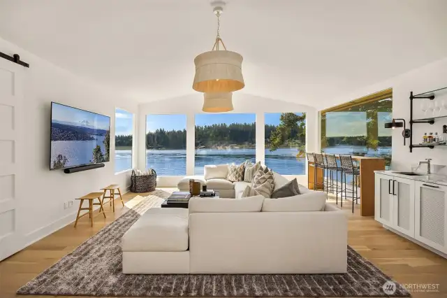 Living room with breathtaking views and built in wet bar w/ bev fridge and icemaker. Top quality designer sourced furnishings.