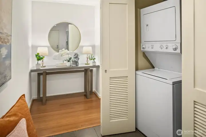 An in-unit washer and dryer conveniently accessed in the entry hall. (photo from previous staging)