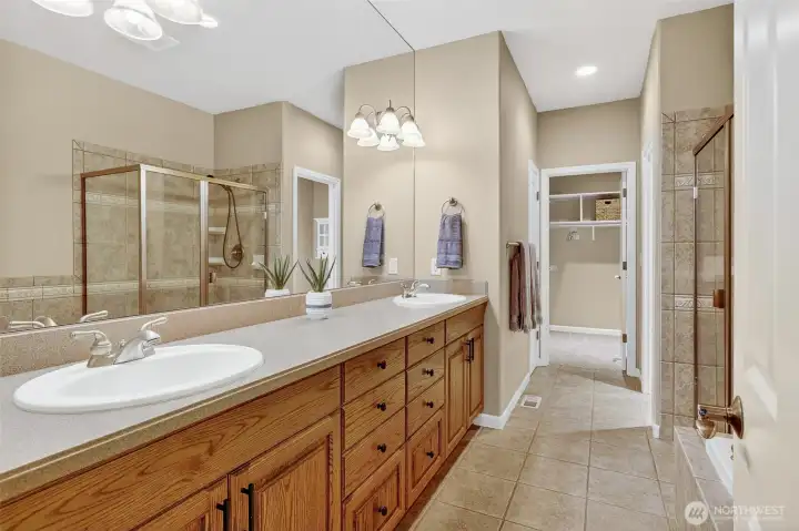 Main floor on suite bathroom with double sinks, toilet closet, walk-in shower and soaker tub