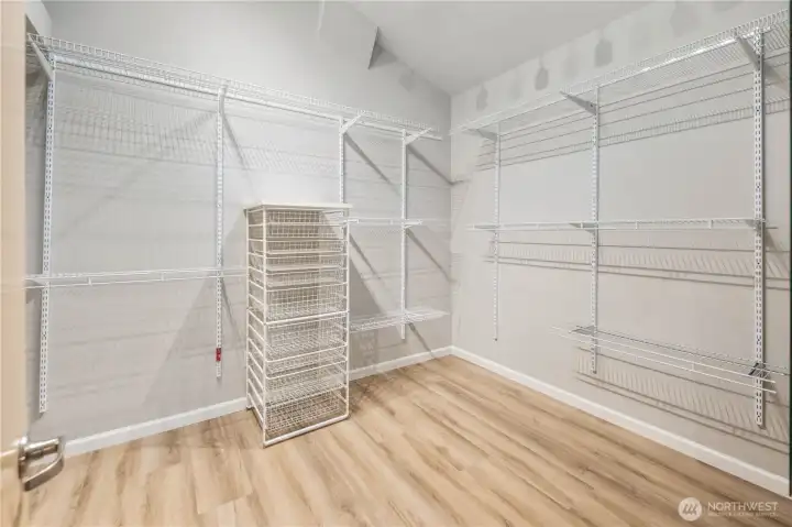 Custom walk-in closet with adjustable shelving, hanging systems, new flooring, bright lighting, and efficient, organized storage design. Private safe.