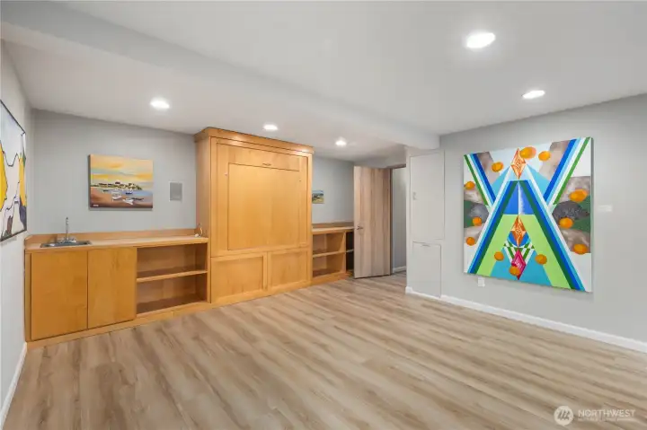 Spacious Murphy bed, bedroom/office  with built-in cabinetry, brand new floors, recessed lighting, and flexible space ideal for media, office, or guests.