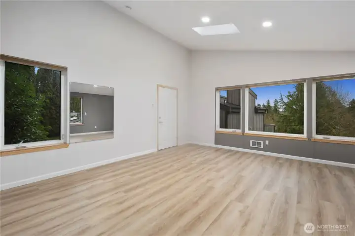 Spacious flex space above two car garage with wide plank floors, large windows, recessed lighting, and flexible layout offering comfort, privacy, and serene natural views.
