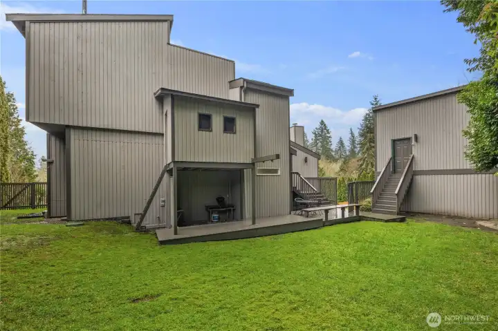 Modern multi-level home with expansive lawns, private decks, and clean architectural lines set amid mature landscaping and open green space.