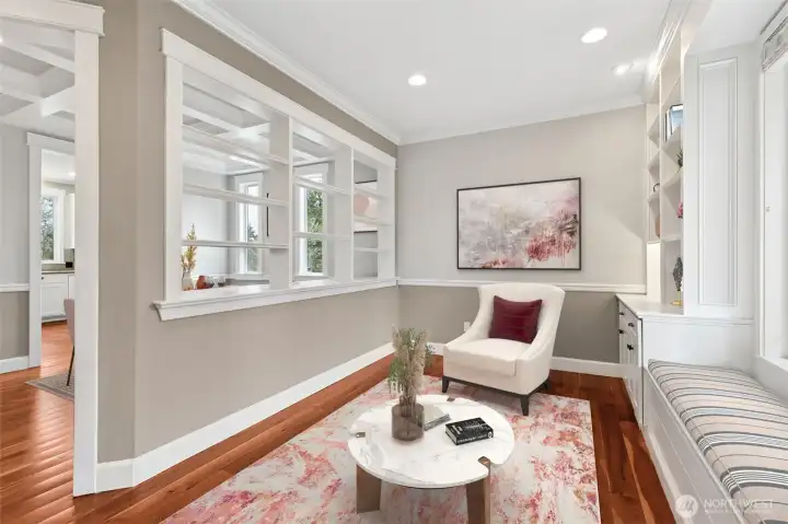 The upper half of the den parlor wall opens into a large pass through that feels like a window without being a window, trimmed out beautifully and finished with built in shelving where panes would normally go. It creates a visual connection into the formal dining room while still letting each space have its own moment. It’s thoughtful, a little unexpected, and exactly the kind of attention to detail to impress.