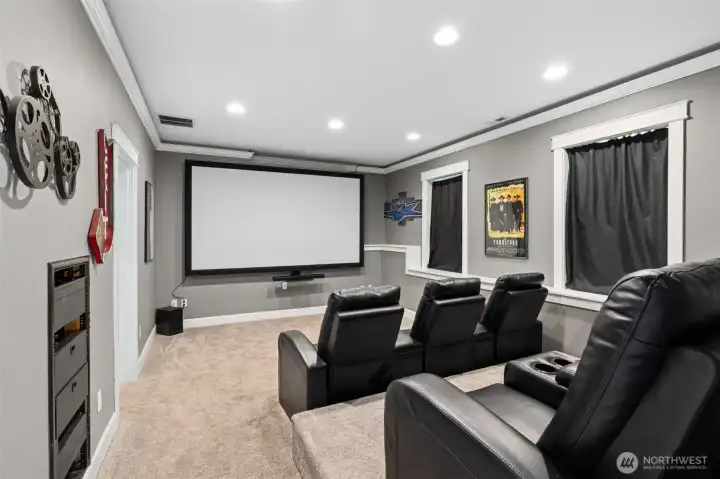 This theater room is ready for opening night. The projection screen stays, the six reclining media chairs with cup holders stay, and yes, they’re tiered so the back row sits higher than the front, just like a real movie theater. The light latte toned carpet keeps things cozy and helps absorb sound, while soft gray walls and recessed lighting set the mood without distractions.