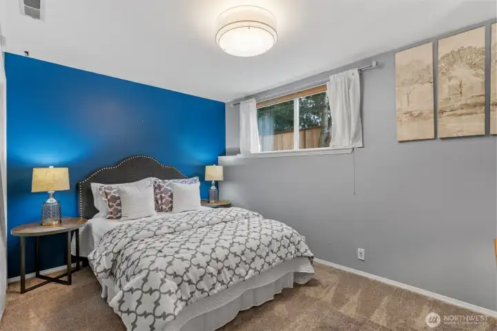 Private lower-level bedroom with easy access to full bath and separate entrance, offering rental or extended living options.