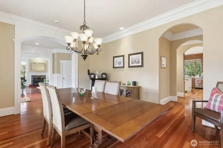 The formal dining room on the right features an arched entrance into the Butler’s pantry with wine fridge and glass upper cabinets.