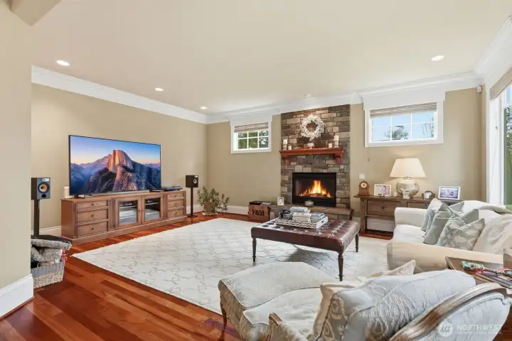 The informal gathering room of the kitchen features a floor to ceiling stone surround gas fireplace with raised hearth.
