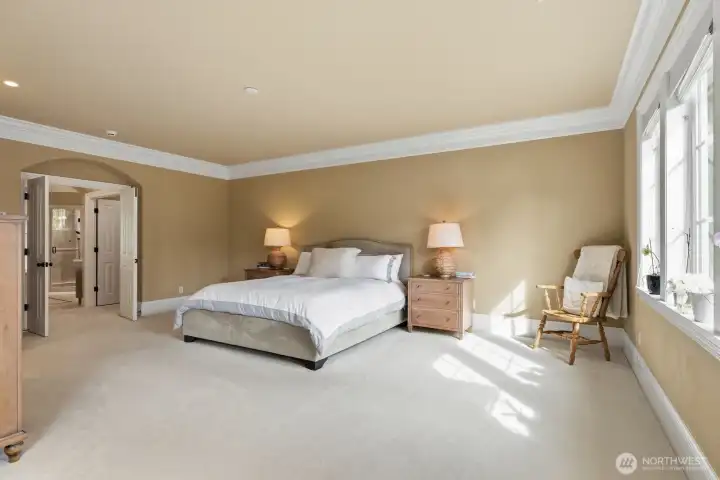 Spacious bedroom with crown molding and double doors.