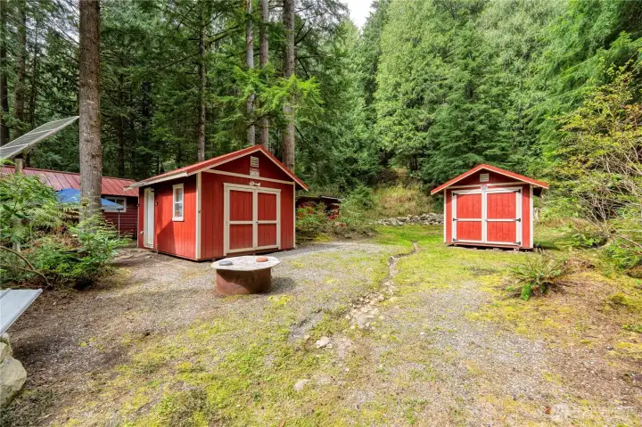 Two newer outbuildings, both impeccably maintained and topped with durable metal roofs that stand up beautifully to the elements.  A 2nd firepit adds versatility to the space.