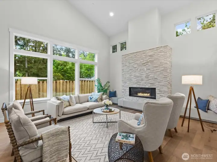 Spacious Great Room with stone gas fireplace, wall of windows and great light. Notice the additional light coming in from the high windows on the fireplace wall. Great seating stone ledge seating for entertaining large groups.