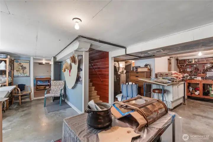 Fully functional basement well organized into workspaces, storage, utility alcove, and laundry. Built-in storage cabinets run along wall just behind the photographer. Fully functional basement well organized into workspaces, storage, utility alcove, and laundry. Built-in storage cabinets run along wall just behind the photographer.
