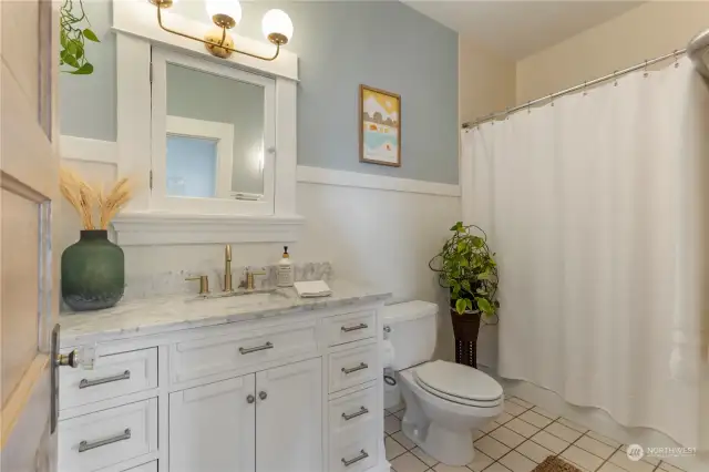 New bathroom vanity with Carrara marble top and designer light fixture.