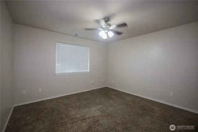 Large primary bedroom, with large window for sunlight.