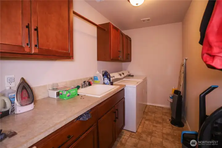 Utility room with cabinets, sink and large area to keep all your cleaning/ laundry supplies.