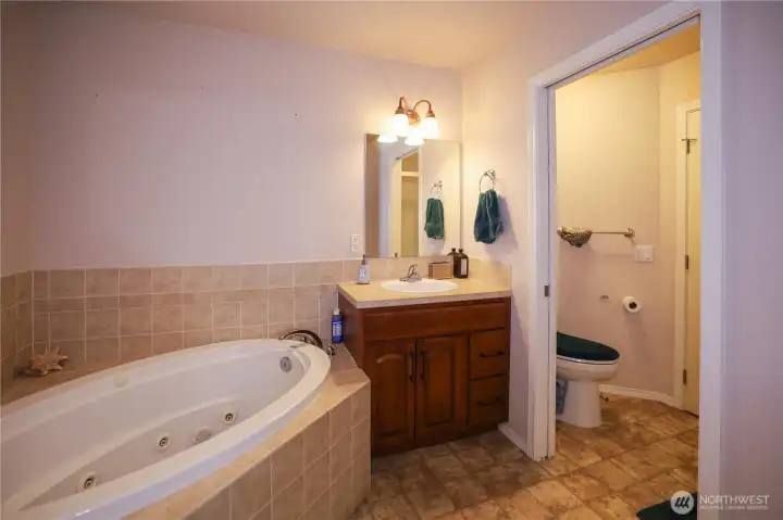 The en suite bathroom has a large jetted garden bathtub and with separate room for toilet with door for privacy  The en suite has a standalone shower as well.