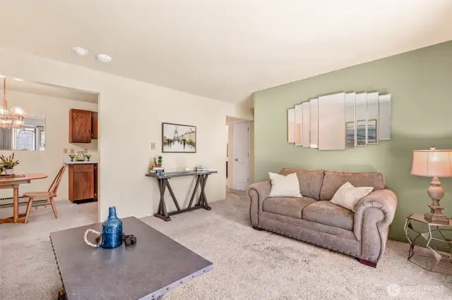 Living room view of dining area and hall.  Accent mirror stays with unit.