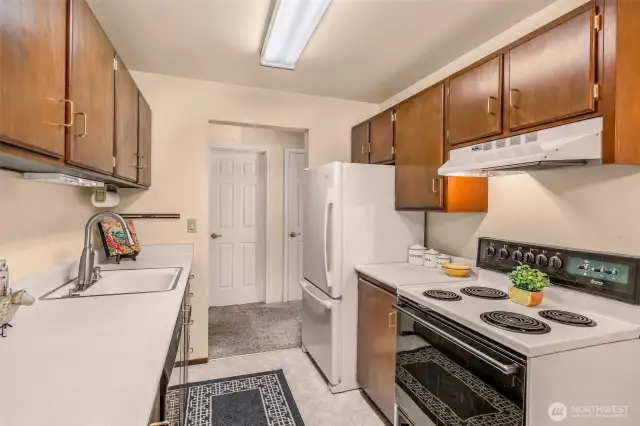 View of kitchen cooking area electric stove with fan.