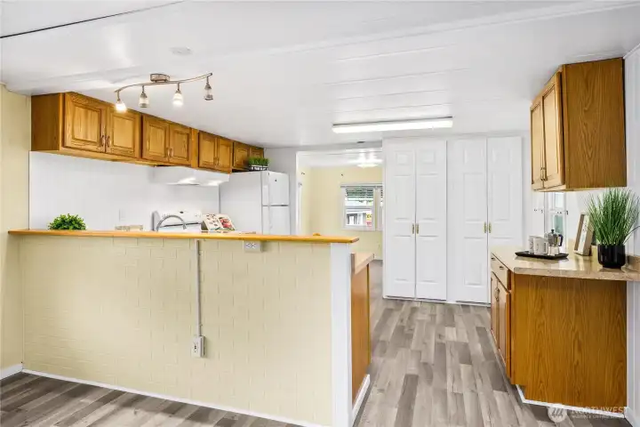 The wall dividing the kitchen is above counter height, and the top could be widened to make it into a breakfast bar.