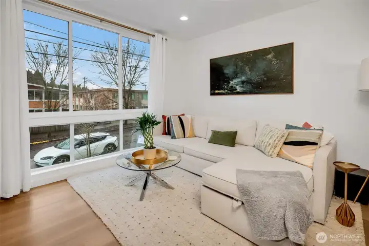 Spacious living area with large windows and abundant natural light. Neutral palette. Easy furniture placement.