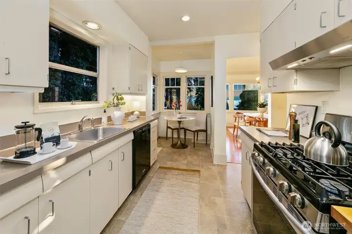 Cozy breakfast nook looks out on large trees, landscaped gardens and more views of the lake!