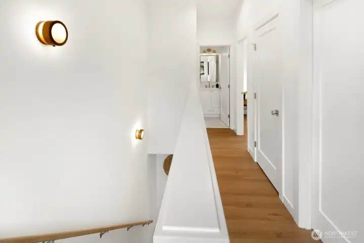 This is the upper landing/hallway. Two bedrooms on the right with a full bath down the hall. Primary suite is on the left.