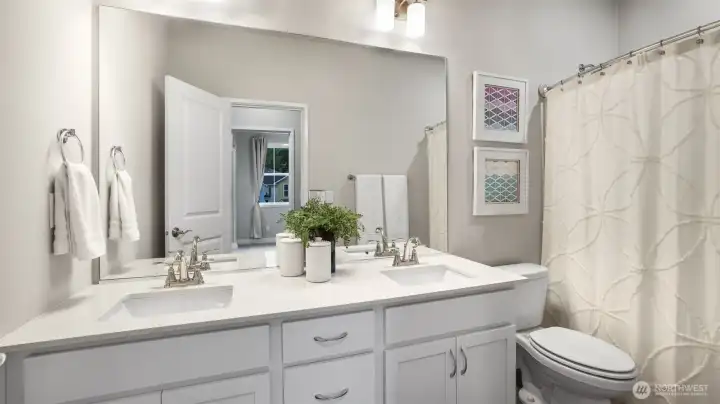 Full bath shared by the two secondary bedrooms complete with dual vanities and quartz counter tops