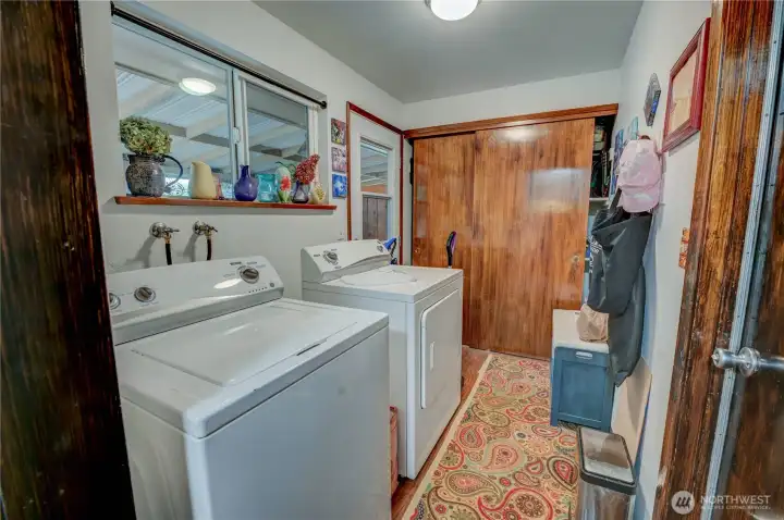 Utility room with a second exterior door to the backyard. Featuring a large Storage closet and access to the garage.