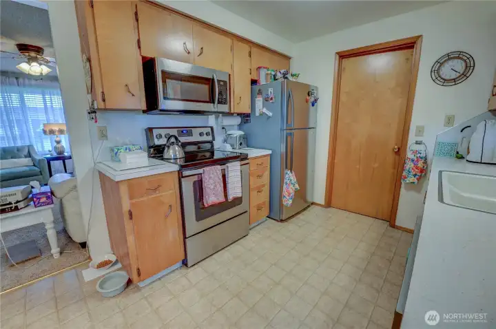 Unit 2021 Kitchen with stainless appliances and laminte floors. Through kitchen leads to the utility room and garage interior entry point, plus access to backyard.