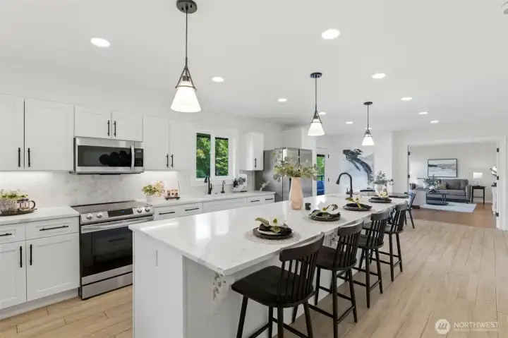 Fully remodeled kitchen featuring granite countertops, stainless steel appliances, oversized island, wine refrigerator, walk-in pantry, and abundant workspace.