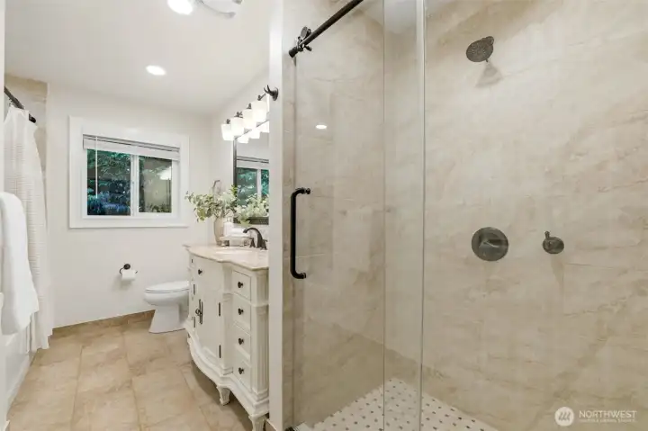 Updated full bath conveniently serving the upper level featuring 2 showers! Thoughtful upgrades including heated bathroom floors add comfort and luxury.
