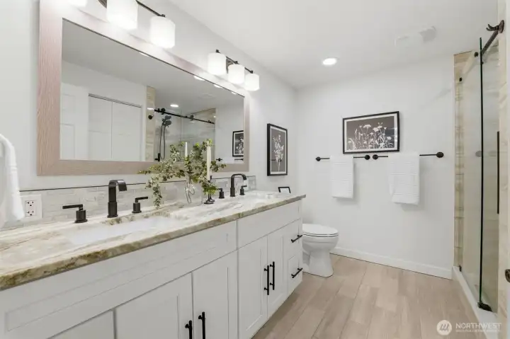 Downstairs bathroom with dual sinks and a shower also includes a washer & dryer (not shown) Thoughtful upgrades including heated bathroom floors add comfort and luxury.
