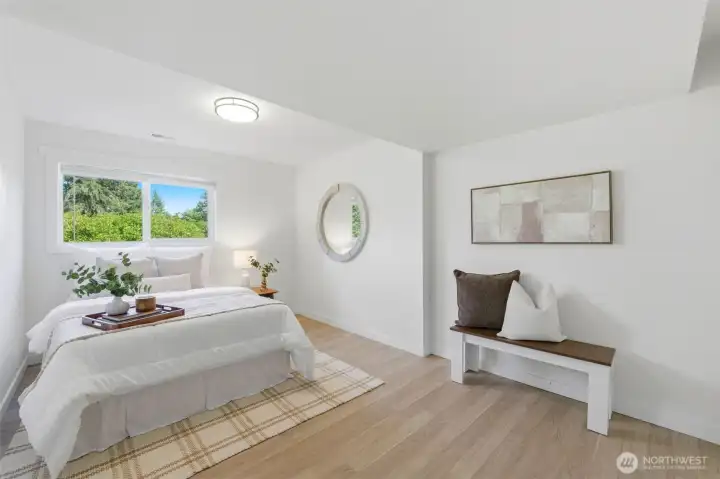 Private lower-level bedroom (1 of 2) ideal for guests or extended household living.
