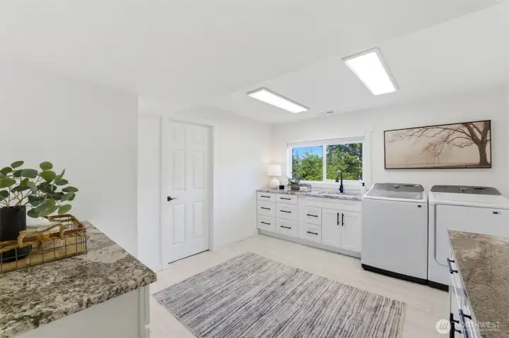 Oversized laundry room with abundant storage and workspace.