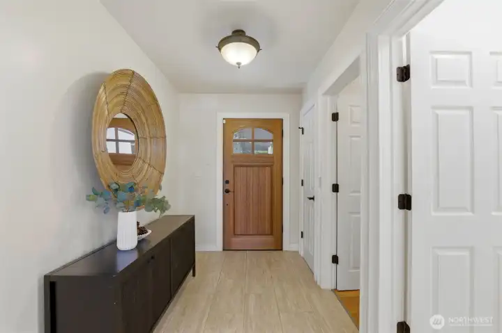 A stunning wood entry door creates a memorable first impression, welcoming guests into a thoughtfully designed floor plan that offers seamless access to the home's gathering spaces, private bedroom wing, and versatile lower level.