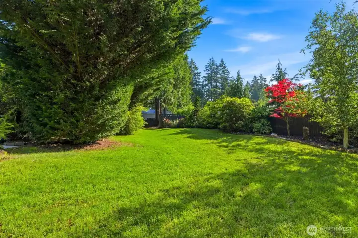 A welcoming arrival framed by towering evergreens, established gardens, and manicured grounds that create a true Pacific Northwest retreat.