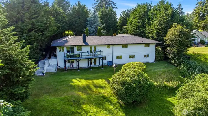 Private backyard sanctuary featuring mature landscaping, expansive lawn, and room to play, garden, or entertain.