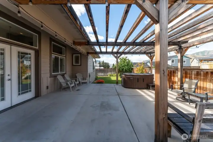 Fully fenced backyard, complete with a pergola-covered patio and hot tub. Fully fenced backyard, complete with a pergola-covered patio and hot tub.