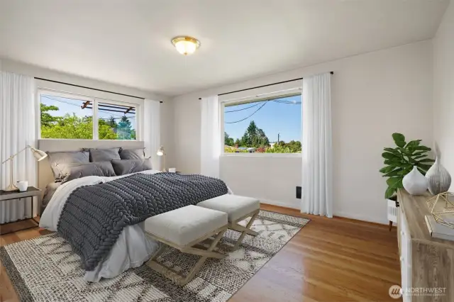 Bedroom off back hallway on main level with lake views and original hardwoods - Virtually staged to show potential.
