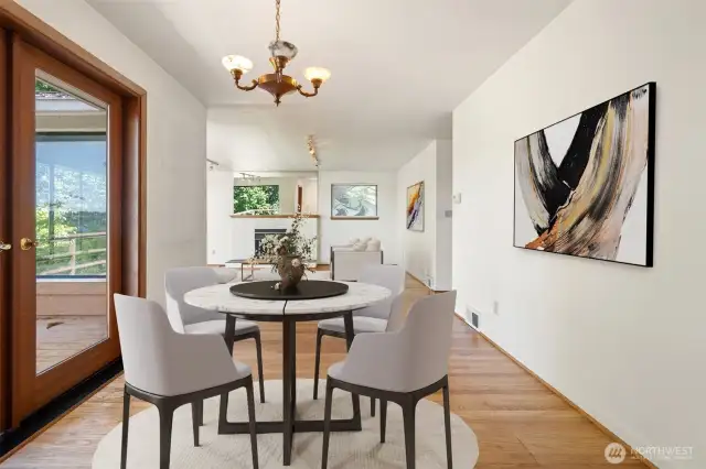 Dining area with french doors out to nice sized view deck and overlooking verdant yard - Virtually staged to show potential.