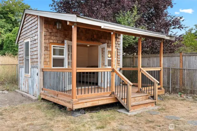 Exterior view of detached heated office with cedar siding & covered porch