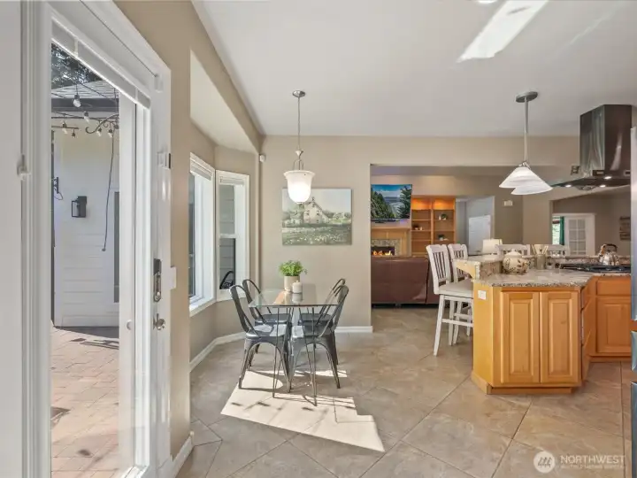 The bright and airy breakfast nook is conveniently located just off the kitchen and island bar, which features a slab granite countertop with a leathered finish.