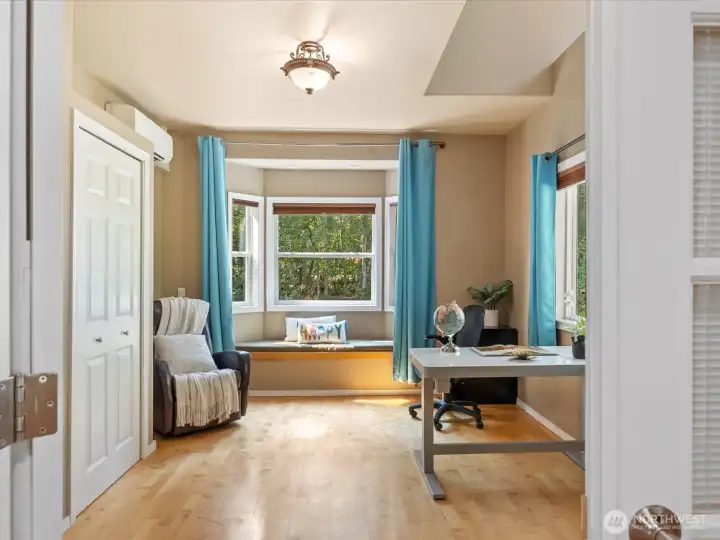 This bedroom, currently used as an office, features a cozy window seat and warm hardwood flooring. A dedicated mini-split AC unit ensures comfort year-round.