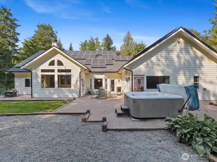 From this vantage point, you can see the hot tub alongside a pea gravel play area—perfect for relaxation and family fun.