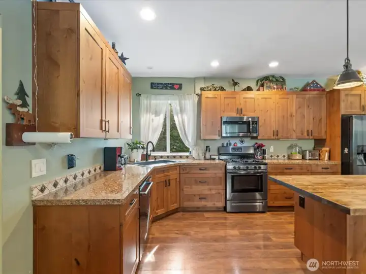 The ADU offers abundant counter space and cabinets, including a huge island with slab granite counters and an under-mount sink. Stainless steel appliances complete the kitchen—perfect for rental income or multi-generational living.