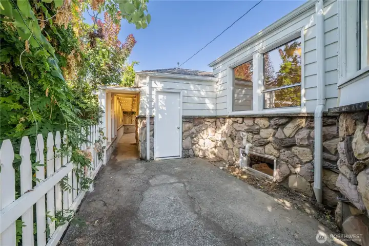 Looking west from the side yard. Backyard walkway & entrance with door into the 1 car garage.