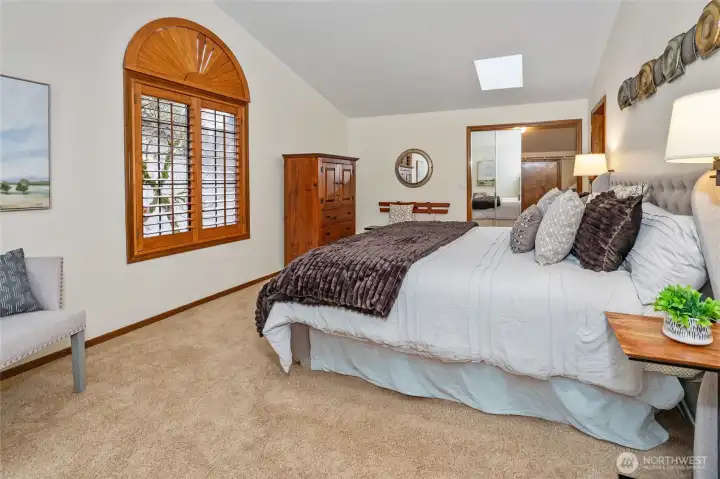 Another view of the primary bedroom looking toward the walk-in closet.