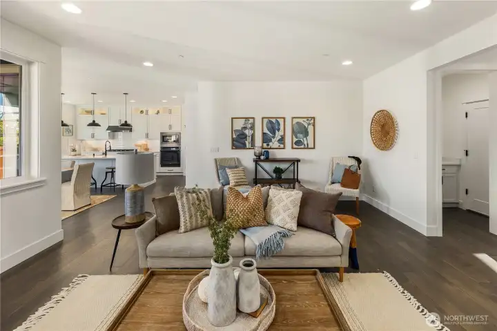 Living Room  The living room centers the main level with a seamless layout designed for flow and connection. Wide plank flooring extends throughout, while recessed lighting and expansive sightlines create an open, cohesive feel between the great room and kitchen beyond. A modern fireplace with textured surround anchors the space, adding warmth and architectural contrast against clean white walls.    Positioned within Bothell near Canyon Park amenities and commuter routes, this integrated living area reflects the craftsmanship associated with high-end contemporary homes. The connected design supports both relaxed daily living and effortless entertaining, a hallmark of thoughtfully built new construction served by the Northshore School District.    These photos are from a past Robinson Plan at a different community, so overall plan, colors, building orientation, finishes, home outlook, and other details can and WILL vary. All photos, renderings, site maps, and floorplans are for visualiz